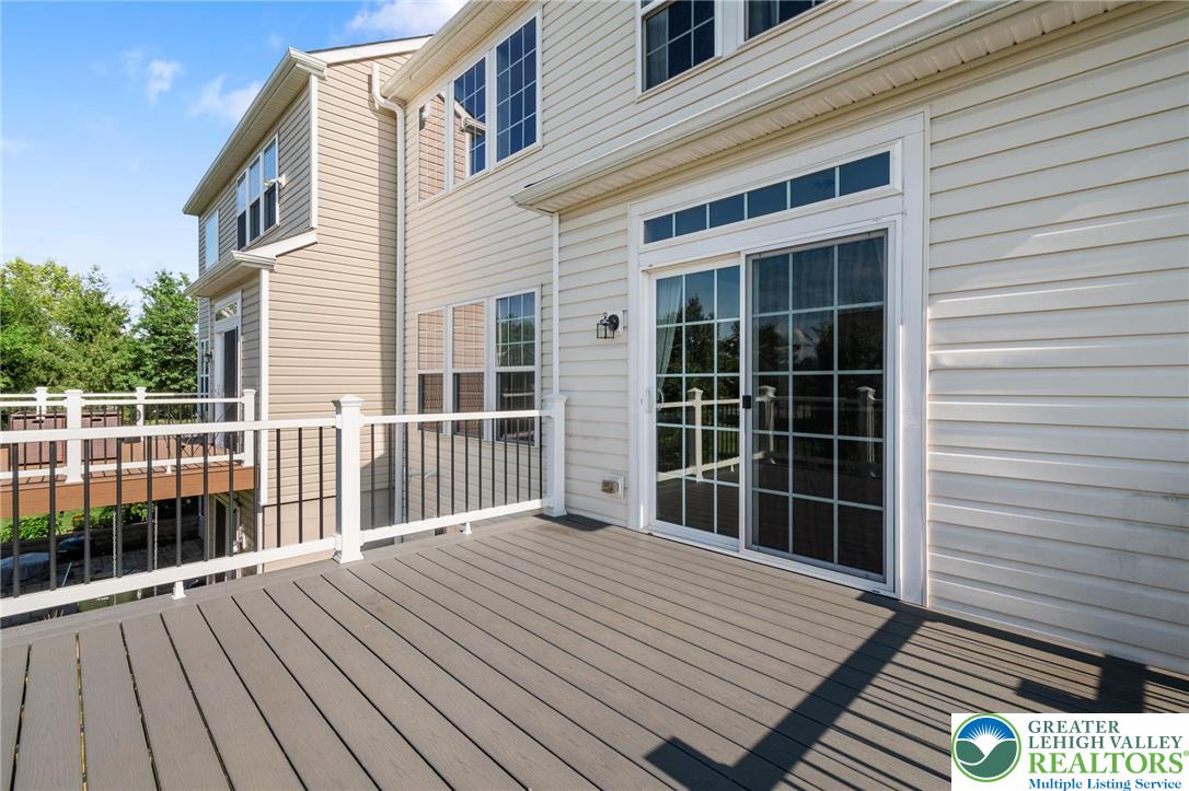 8455 Starling Road Breinigsville, PA 18031 - Photo 22 of 24 Step out onto this spacious deck featuring sliding glass doors and durable siding, perfect for outdoor living.