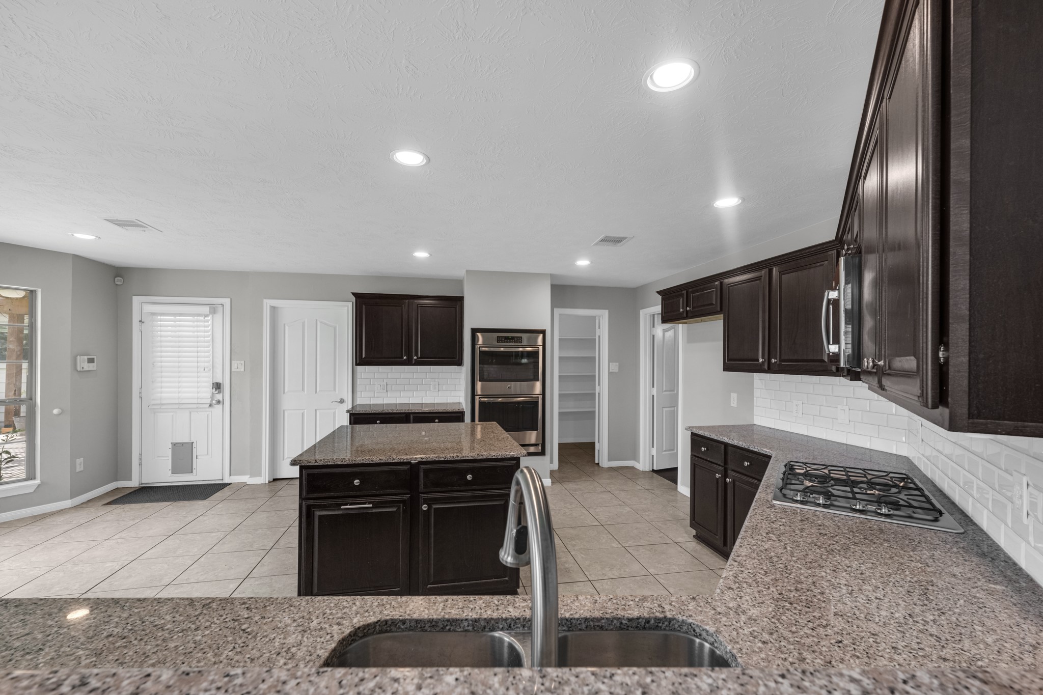 6606 Granbury Road Manvel, TX 77578 - Photo 19 of 48 The kitchen is also featuring a double-oven, built-in microwave, and a spacious island.