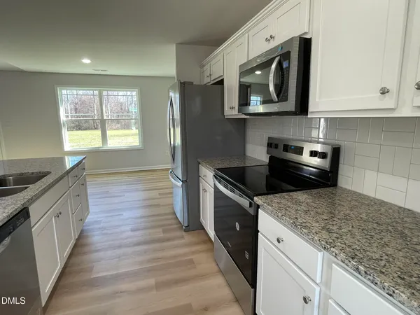 a kitchen with stainless steel appliances granite countertop a sink stove and microwave