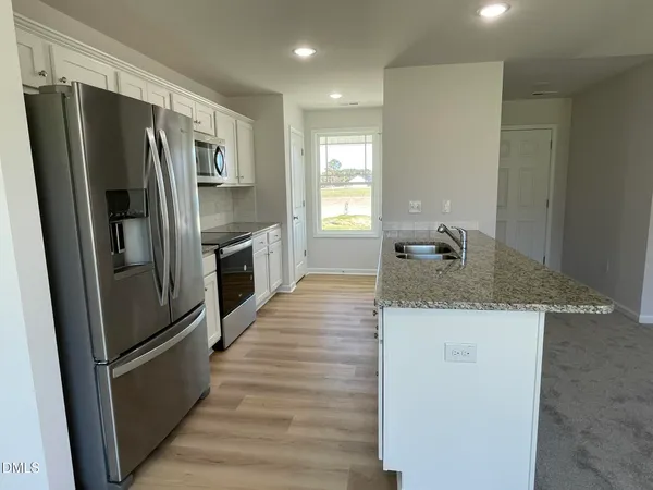 a kitchen with granite countertop a refrigerator and a sink