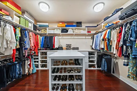 a view of walk in closet with clothes and shoes