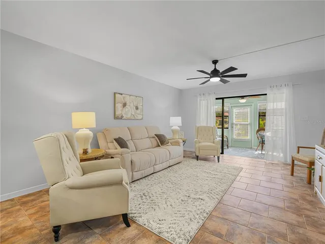 a living room with furniture and a ceiling fan