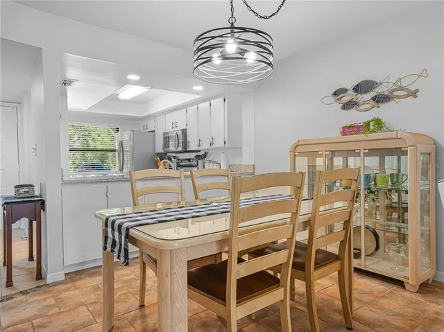 a view of a dining room with furniture a chandelier and wooden floor