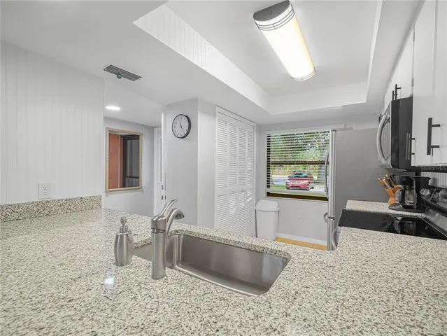 a large bathroom with a granite countertop sink and a large mirror