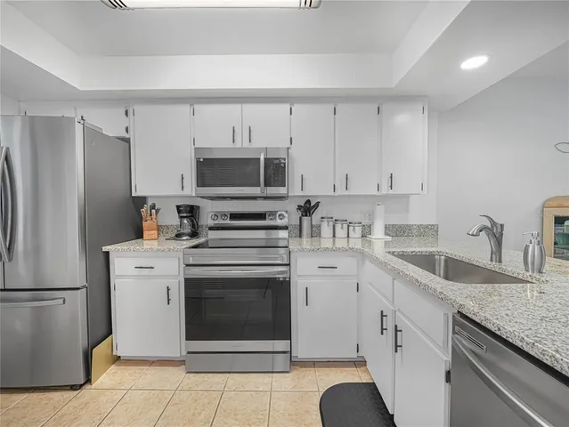 a kitchen with cabinets stainless steel appliances and a counter space