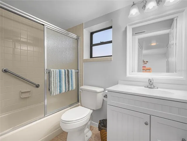 a bathroom with a sink toilet vanity granite tub and shower