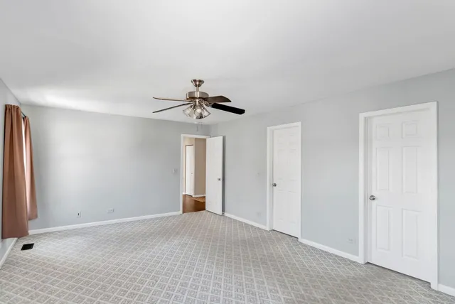 a view of empty room with ceiling fan