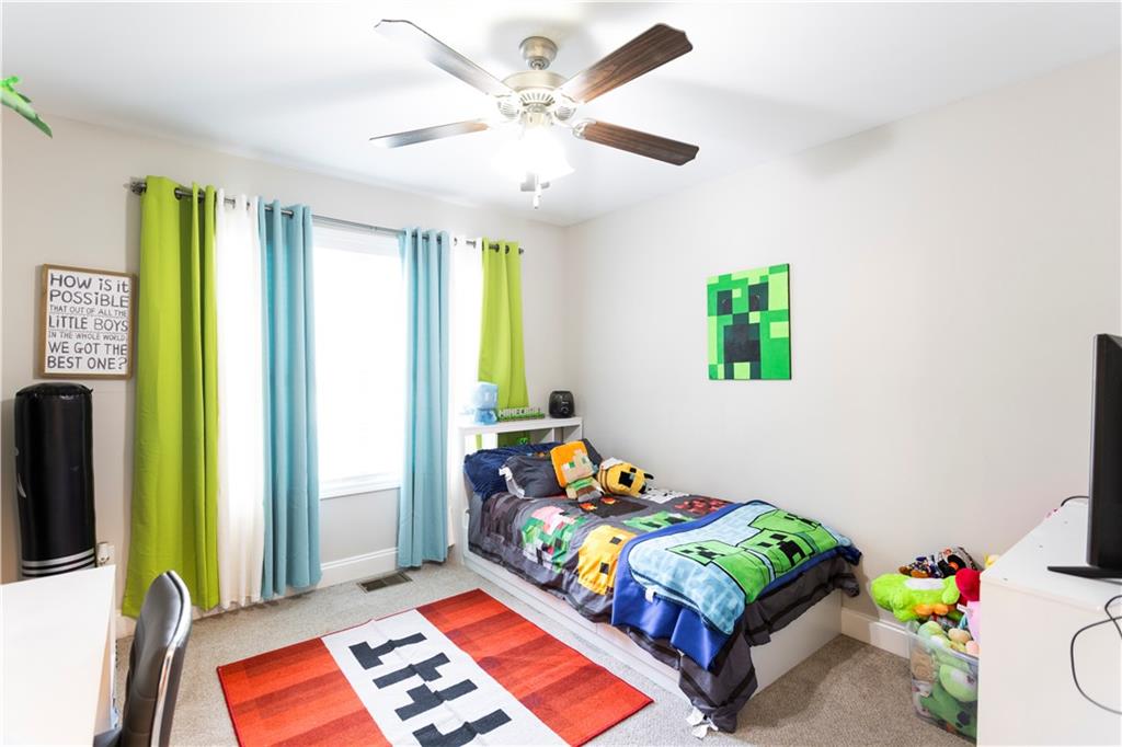 355 Conner Court Social Circle, GA 30025 - Photo 29 of 52 a bedroom with a bed and a chandelier