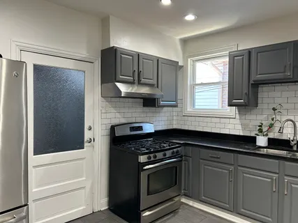 a kitchen with stainless steel appliances granite countertop white cabinets and window