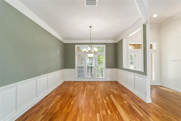 a view of a room with wooden floor and chandelier