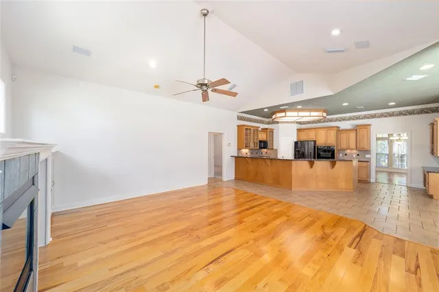 a view of a large kitchen with granite countertop a sink and a counter top space
