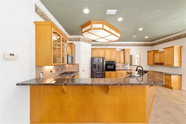 a kitchen with stainless steel appliances granite countertop a sink stove and refrigerator
