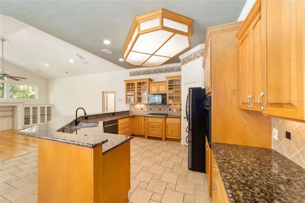 a view of a kitchen with kitchen island a large window cabinets and stainless steel appliances