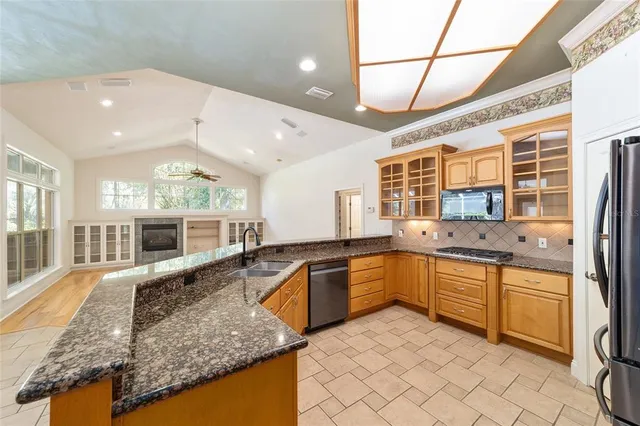 a view of a kitchen with kitchen island a large window cabinets and stainless steel appliances
