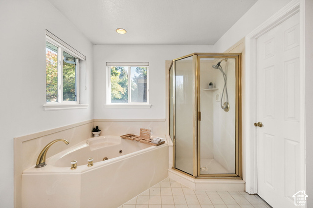 1143 East Mountain Road Logan, UT 84321 - Photo 14 of 64 Built-in soaking tub with brass fixtures, individual shower enclosure with glass panels, and light-toned tile flooring