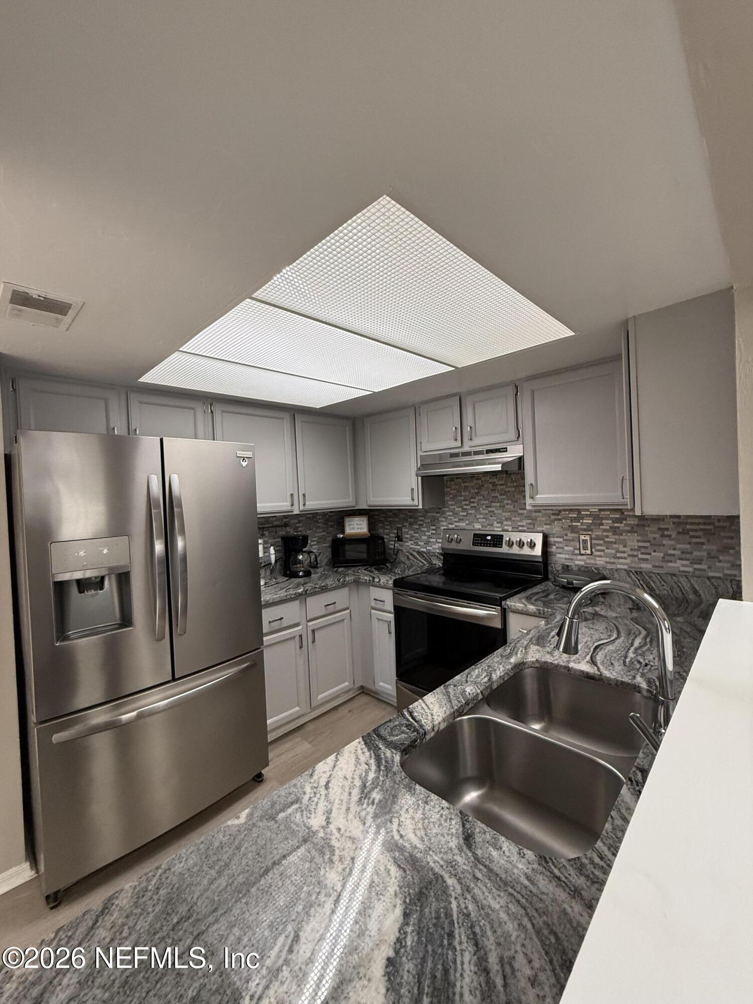 2360 Bitternut Way Jacksonville, FL 32246 - Photo 6 of 26 a kitchen with stainless steel appliances granite countertop a sink stove and refrigerator