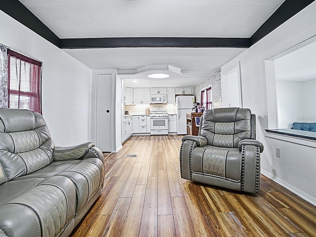 211 Rue De Paresse Tavares, FL 32778 - Photo 11 of 27 a living room with furniture and a wooden floor