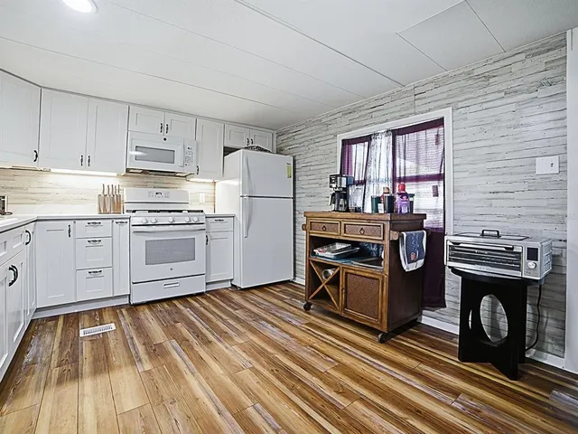 a kitchen with appliances cabinets and a table