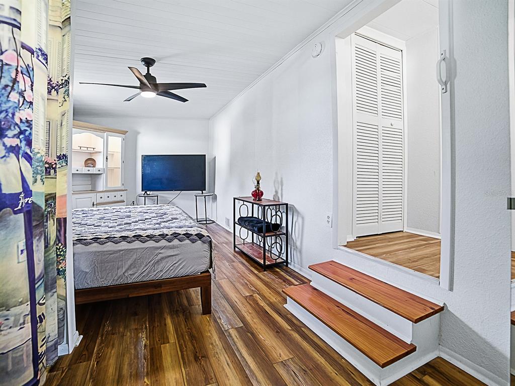 211 Rue De Paresse Tavares, FL 32778 - Photo 14 of 27 a bedroom with a bed and a chandelier