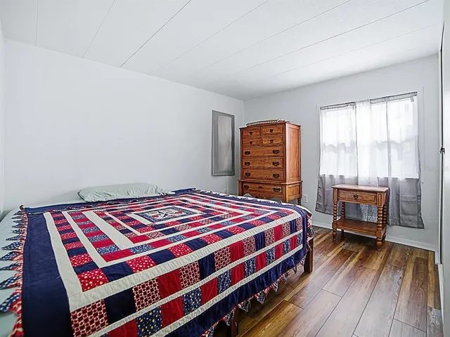 a bedroom with a bed table and a window