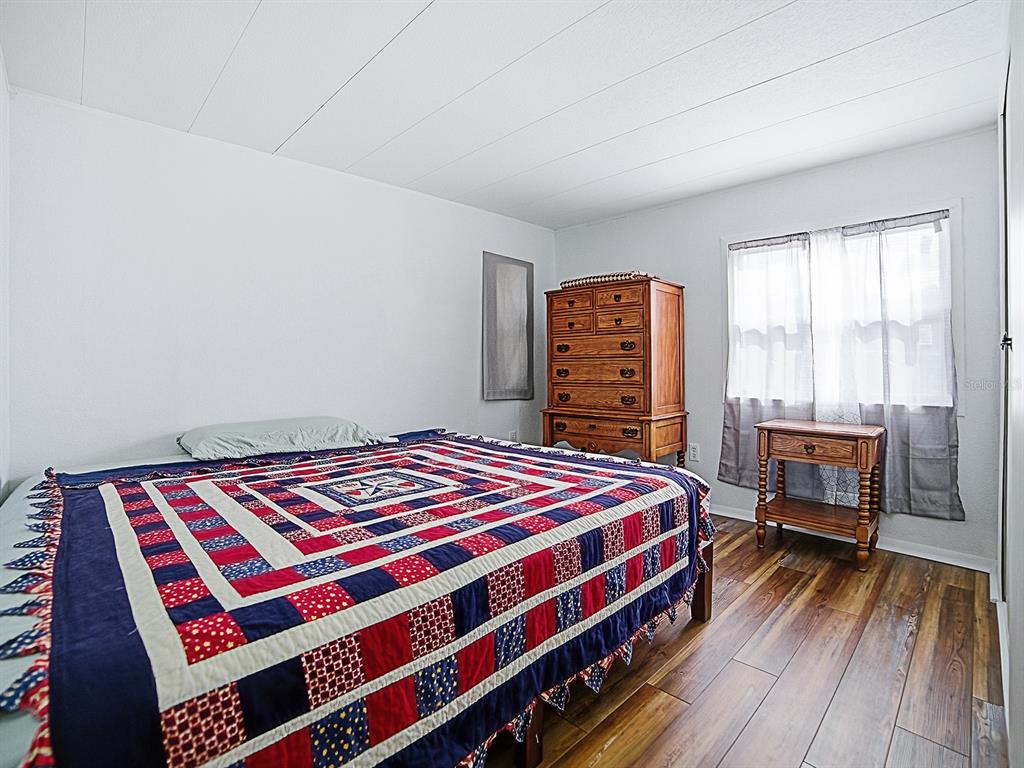 211 Rue De Paresse Tavares, FL 32778 - Photo 16 of 27 a bedroom with a bed table and a window