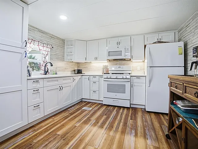 a kitchen with white cabinets and white appliances