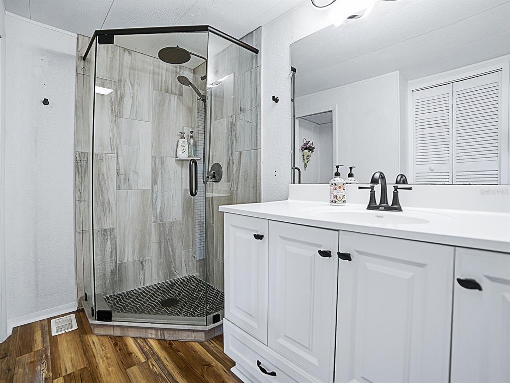 211 Rue De Paresse Tavares, FL 32778 - Photo 6 of 27 a bathroom with a shower sink vanity and mirror