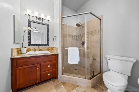 a bathroom with a granite countertop sink toilet and shower