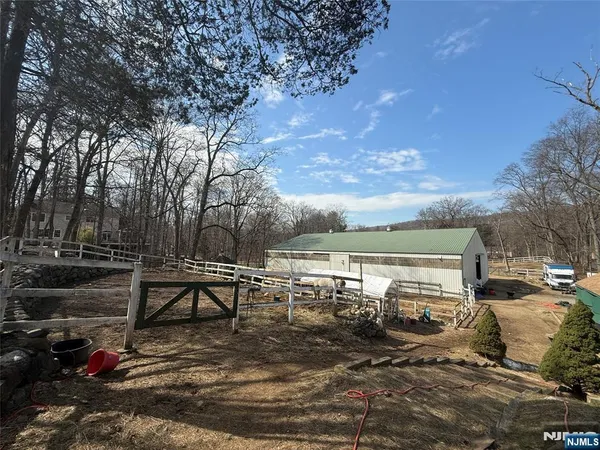 a swimming pool with a yard and trees in the background