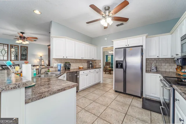 a kitchen with stainless steel appliances granite countertop a refrigerator and a sink
