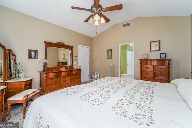 a bedroom with a bed and dresser with mirror