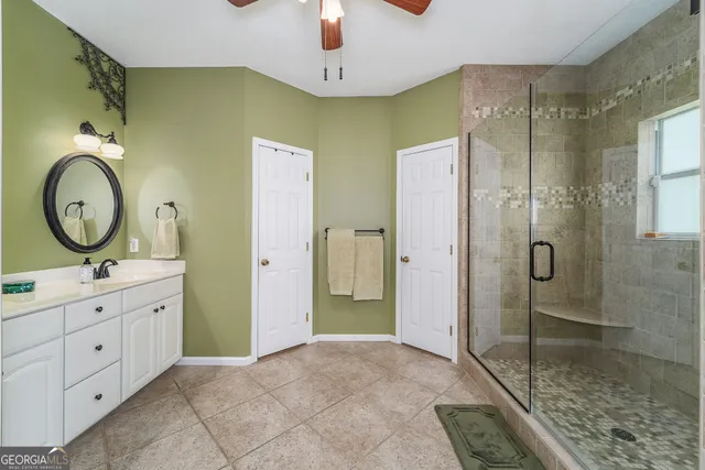 a bathroom with a granite countertop sink mirror and shower