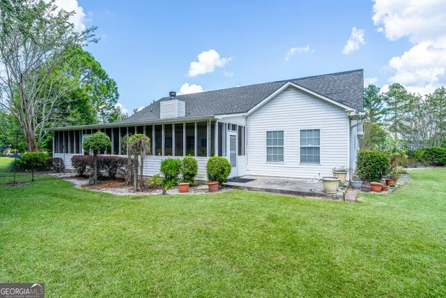 a view of a house with a backyard and a patio