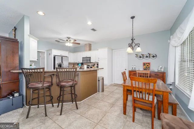 a view of a dining room with furniture and a chandelier