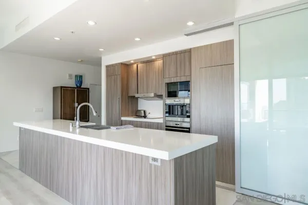 a kitchen with kitchen island granite countertop a stove and a sink