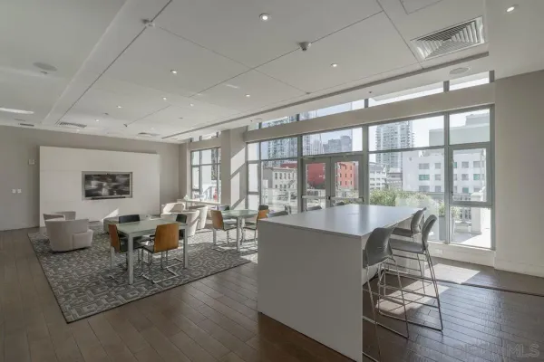 a living room with furniture large window and wooden floor