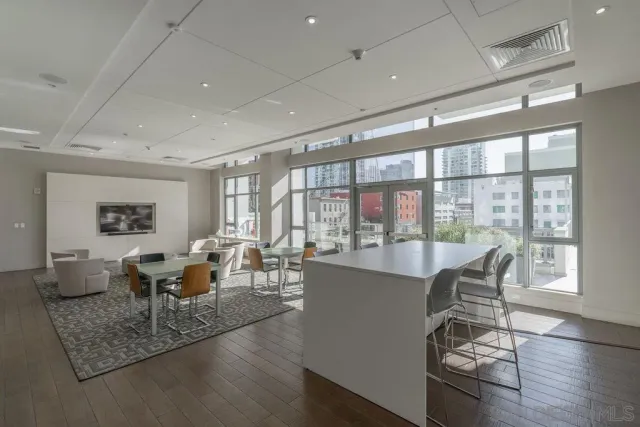 a living room with furniture large window and wooden floor