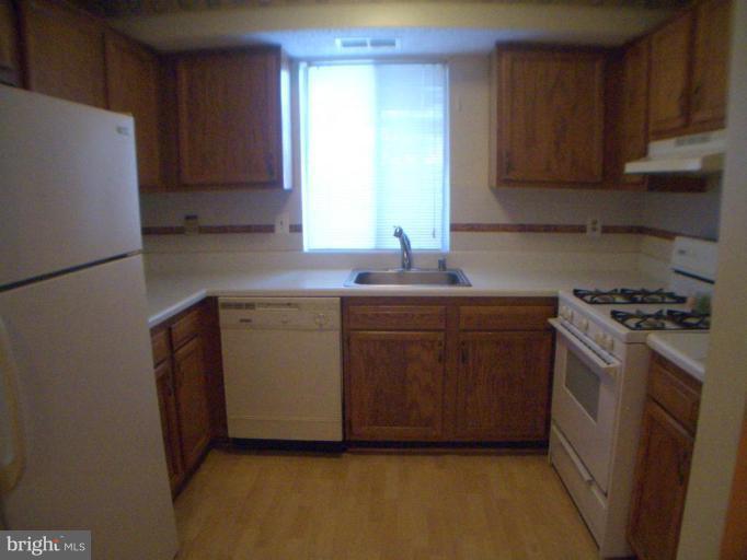 12007 Tarragon Road, Unit 12007 Reisterstown, MD 21136 - Photo 6 of 10 a kitchen with a sink a stove and a refrigerator