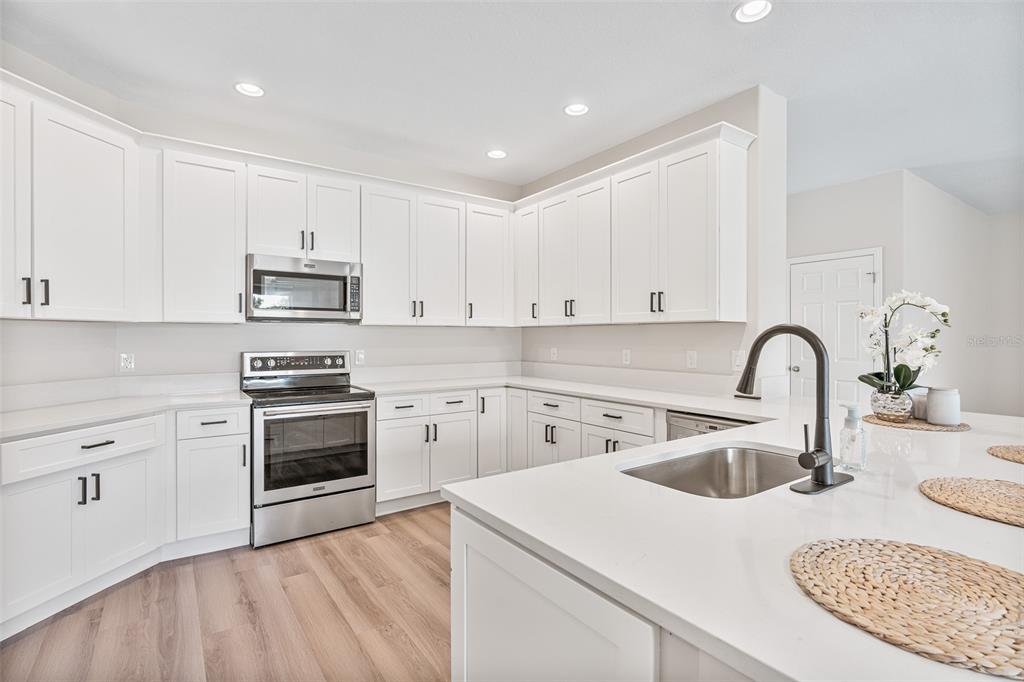 3333 Atmore Terrace Ocoee, FL 34761 - Photo 3 of 37 a kitchen with sink a stove and cabinets