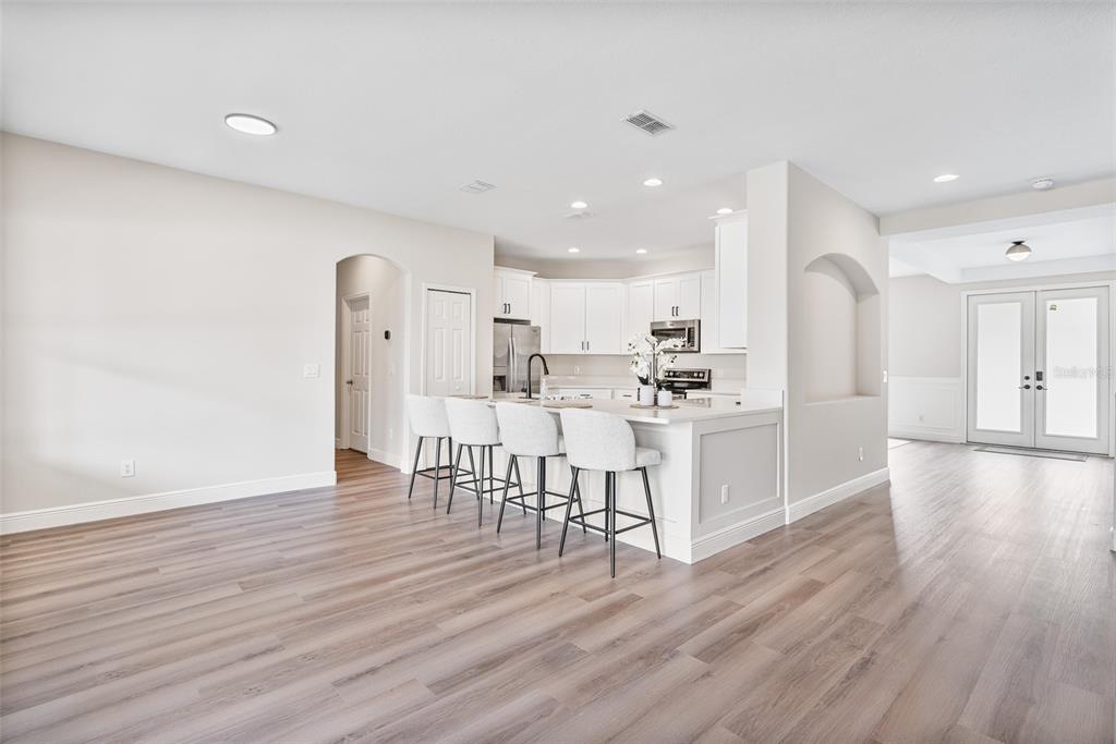3333 Atmore Terrace Ocoee, FL 34761 - Photo 5 of 37 a kitchen with white cabinets stainless steel appliances with chair and table
