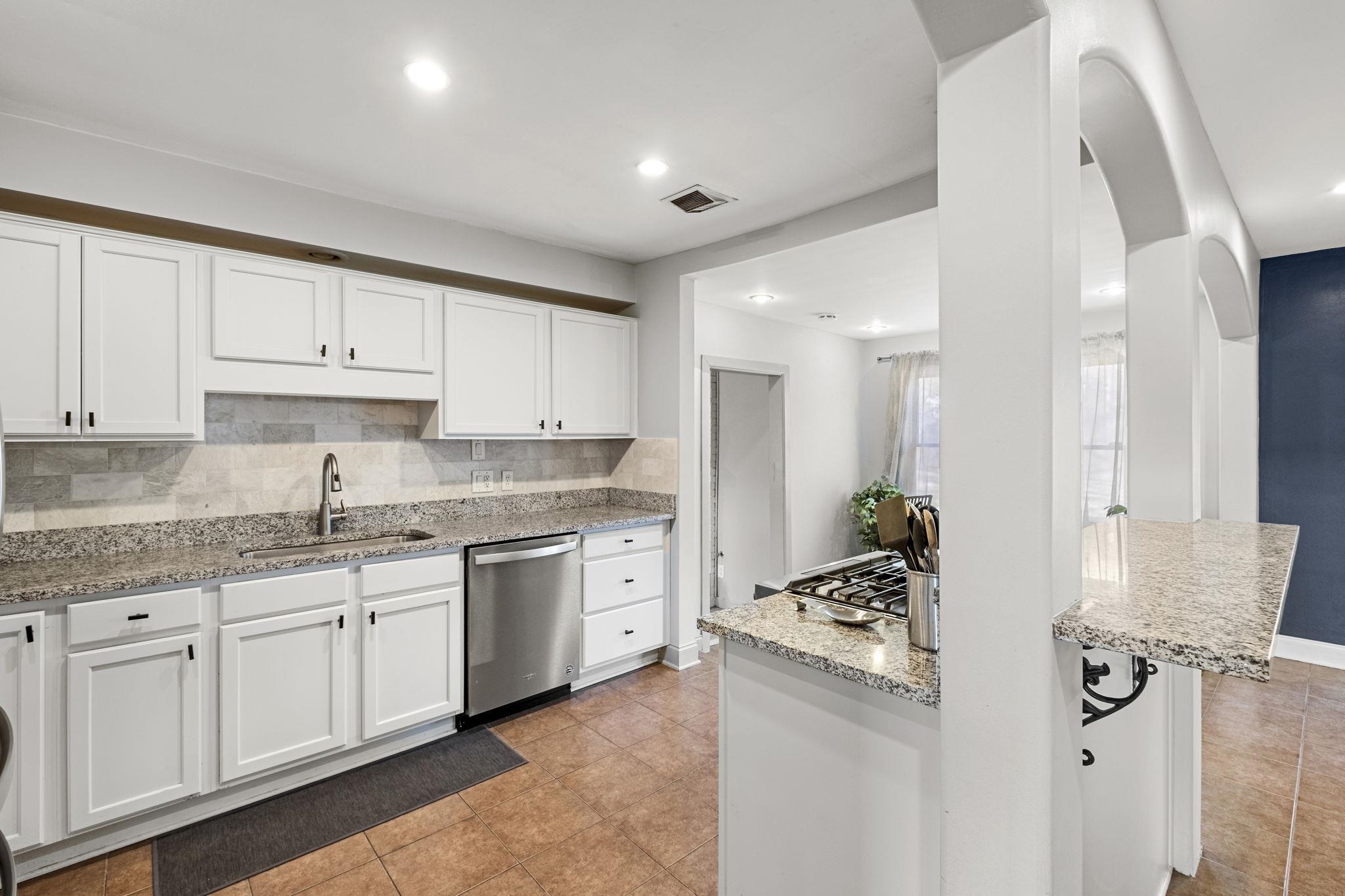 4120 Village Road Memphis, TN 38117 - Photo 8 of 28 Kitchen with white cabinets, light stone countertops, stainless steel dishwasher, backsplash, and recessed lighting