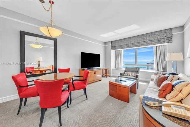 a living room with furniture a flat screen tv and a window