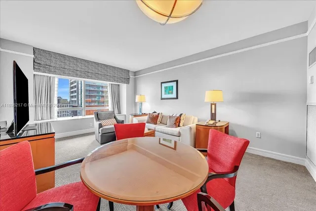 a living room with furniture a flat screen tv and a window