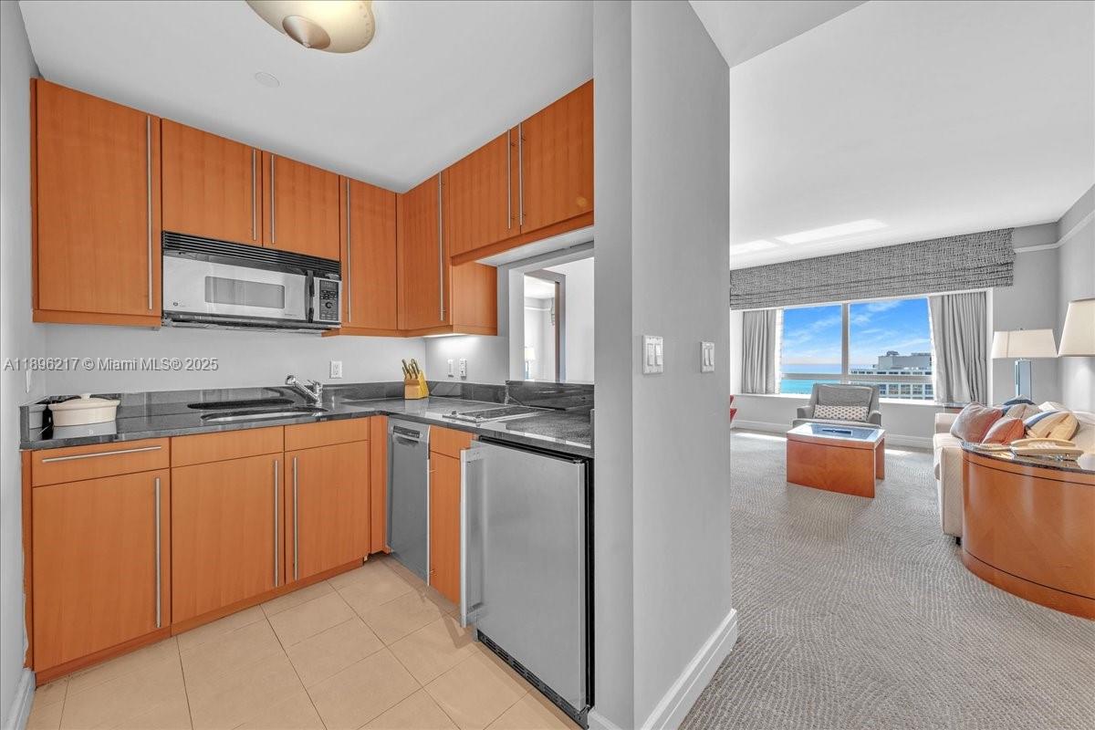 1435 Brickell Avenue, Unit 3603 Miami, FL 33131 - Photo 8 of 26 a kitchen with stainless steel appliances granite countertop a stove top oven a sink dishwasher and a microwave oven on the blue kitchen countertops