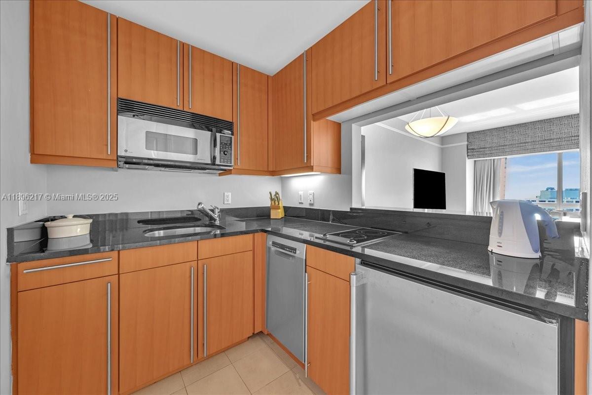 1435 Brickell Avenue, Unit 3603 Miami, FL 33131 - Photo 9 of 26 a kitchen with stainless steel appliances granite countertop a sink stove and microwave