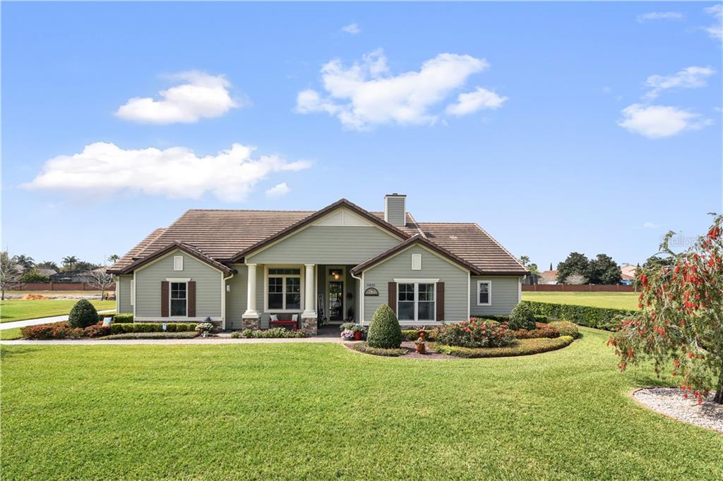 a front view of a house with a garden and yard