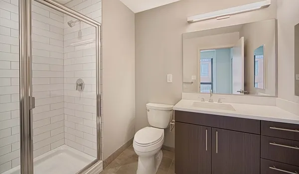 a bathroom with a sink a toilet and shower