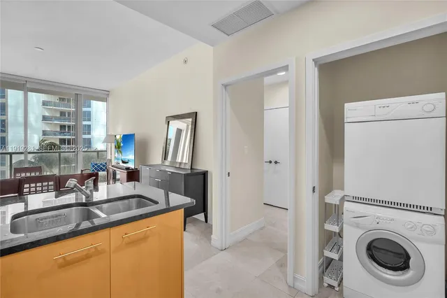 a large kitchen with stainless steel appliances granite countertop a sink and a refrigerator