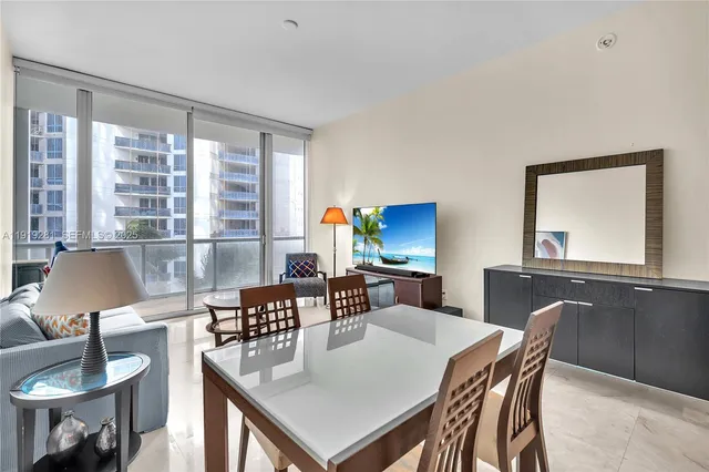 a living room with furniture a flat screen tv and a dining table