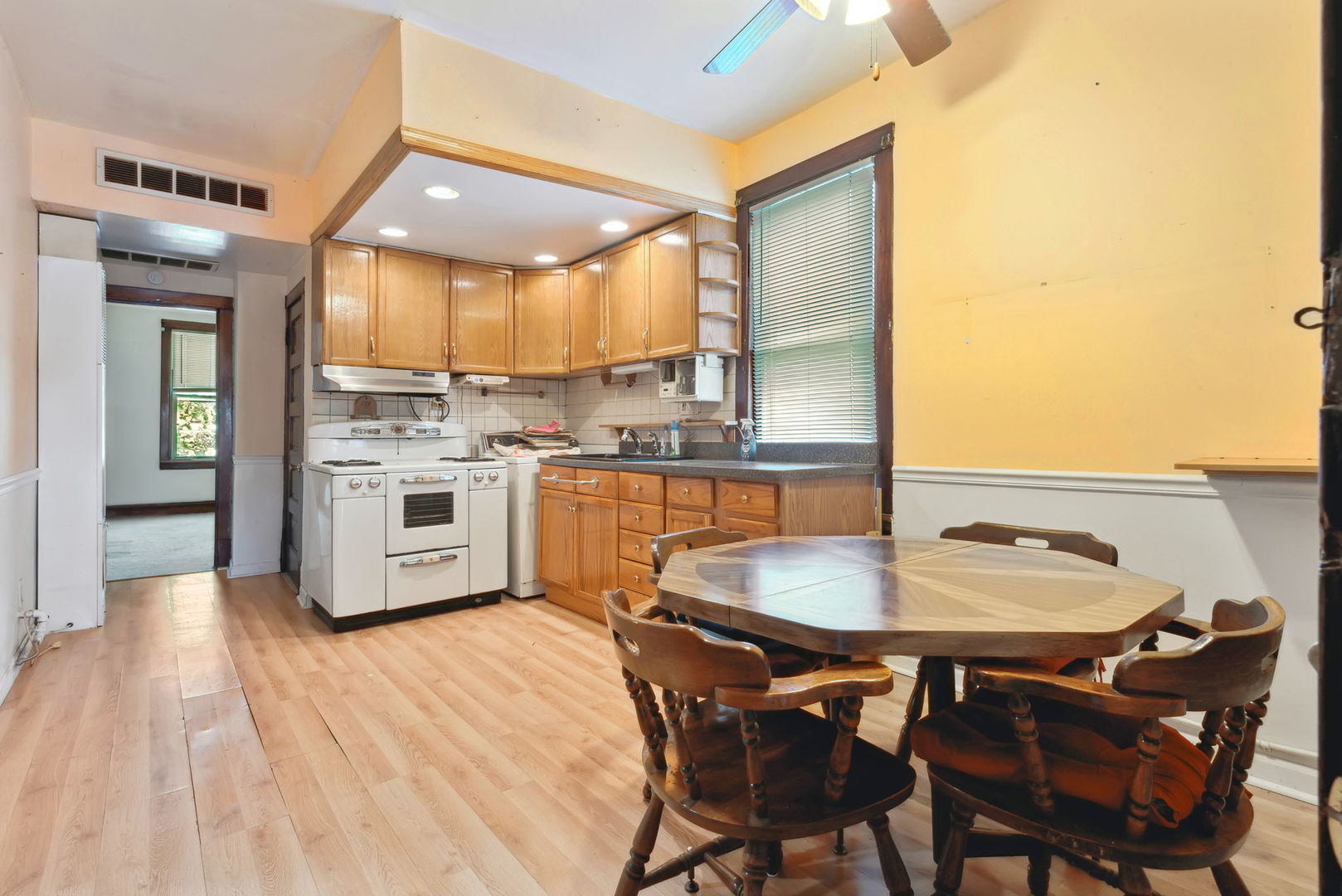 4411 West Haddon Avenue Chicago, IL 60651 - Photo 3 of 21 a kitchen with a dining table chairs and white cabinets